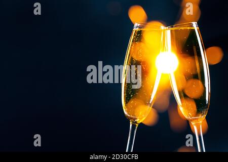 Zwei Gläser Champagner klirren mit funkelnden Bokeh-Lichtern in Der Hintergrund Silvester Party Feier Konzept Stockfoto