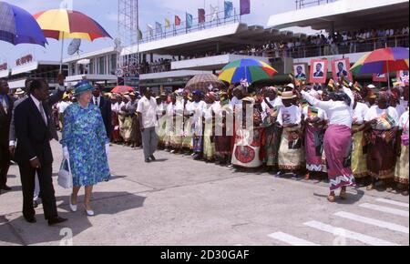HM Königin Elizabeth II., begleitet von Präsident Joaquim Chissano, (links) von Mosambik wird von traditionellen Tänzern begrüßt, als sie am Flughafen Maputo für eine Whistle-Stop-Tour durch die Hauptstadt des Landes am letzten Tag ihres Staatsbesuchs in Afrika ankommt. * Es ist der erste Besuch der Königin beim neuesten Mitglied des Commonwealth, das sich von 16 Jahren Bürgerkrieg erholt. Stockfoto