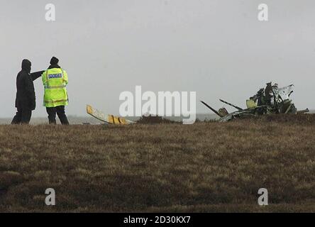 Polizeibeamte stehen in der Nähe des Wracks eines Hubschraubers, der auf Moorland in der Nähe von Bolton, Lancashire, abgestürzt ist. Eine Flugunfalluntersuchung ist im Gange, nachdem drei Männer getötet wurden, als ihr Hubschrauber am 1. Februar 2000 bei schlechtem Wetter abgestürzt war. * das Privatflugzeug, das von Blackpool nach Coventry flog, stürzte gegen 17 Uhr bei nebligen Bedingungen in White Coppice, auf Anglezarke Moor, bei Bolton ab. Stockfoto