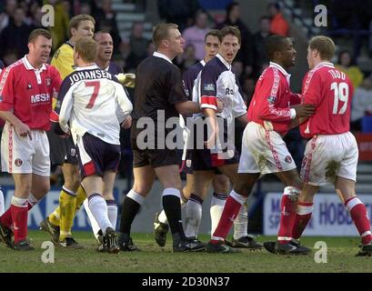 Schiedsrichter Graham Poll (Mitte, schwarzes Shirt) ist von Charlton Athletic und Bolton Wanderers Spielern umgeben, nachdem er Dean Holden von Bolton während ihres FA Cup Quarter Final Fußballspiels im Reebok Stadium, Bolton, geschickt hat. Stockfoto