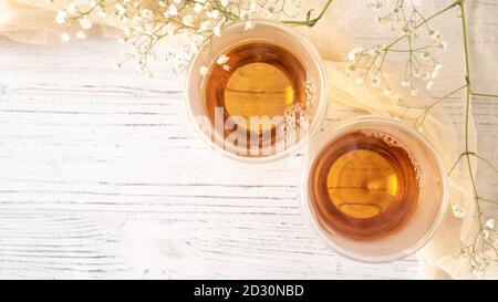 Kein Ansturm im Sommer Morgen mit duftenden goldenen Tee in Glas Tassen. Blick von oben Coups von Tee. Blume. Holzhintergrund Stockfoto