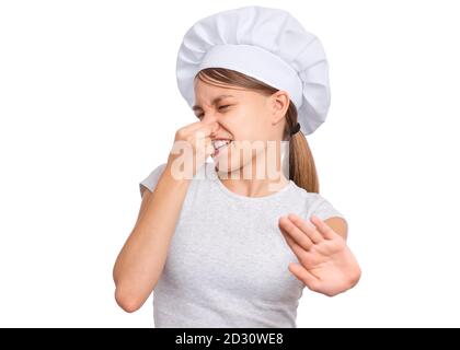 Mädchen trägt einen Koch Hut, kneift Nase mit Fingern sieht mit Ekel, isoliert auf weißem Hintergrund. Stockfoto