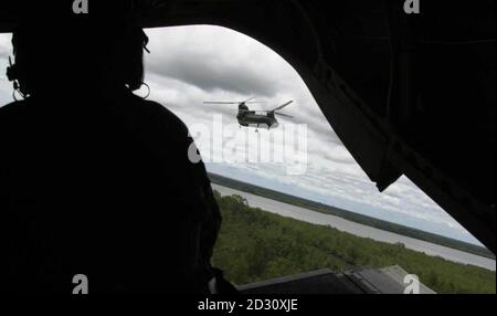 Der hintere Schütze des Chinook beobachtet, wie ein anderer Chinook über Sierra Leone flyt. Die britischen Hubschrauber-Crews der Royal Air Force Chinook halten ein wachsames Auge auf Anzeichen von Rebellenaktivitäten. * Obwohl sie in erster Linie die Arbeitspferde der britischen Streitkräfte in dem vom Streit zerrissenen westafrikanischen Staat sind und Truppen und Ausrüstung befördern, bieten sie auch eine zusätzliche Dimension für Kommandeure, die versuchen, den Rebellen Ruf aufzuspüren. Stockfoto