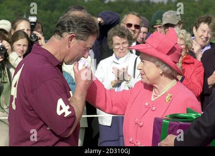 Der Prinz von Wales küsst die Hand seiner Mutter, der Königin, nachdem er den Westbury Polo Cup im Guards Club, Windsor Great Park, Royal Ascot gewonnen hat. Das Prince's Team, Everettnet, schlug den Guards Polo Club 6-3 und eine Hälfte. Stockfoto