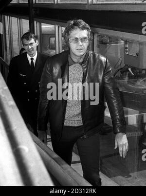 Der amerikanische Schauspieler und Rennfahrer Steve McQueen (rechts) verlässt den Flughafen Heathrow in London, wo er nach Frankreich fährt, um am 24-Stunden-Rennen von Le Mans teilnehmen zu können. Stockfoto