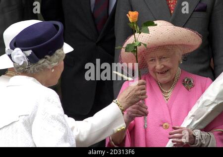 Die Königin, vorne links, und die Königin Mutter, die eine Rose gegeben wird, während sie die Kirche auf dem Sandringham Estate, Norfolk, verlässt. Stockfoto