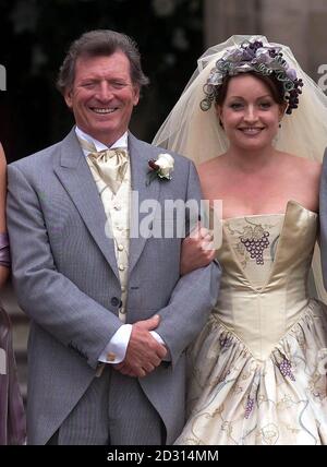 Mike Baldwin von der Coronation Street, gespielt von Johnny Briggs (L), nachdem er den Knoten mit Linda Sykes zusammengebunden hatte, die von Jacqueline Pirie gespielt wurde, die seinen Sohn Mark Redman hinter seinem Rücken bettete. *... Mike und Linda wurden in einer üppigen Zeremonie in einem Cheshire Landhaus, Arley Hall geheiratet. Stockfoto