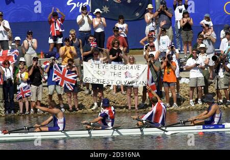 Britische Fans feiern, nachdem Team GB Ruderer (von links nach rechts) Matthew Pinsent, Tim Foster, Steve Redgrave und James Cracknell die Goldmedaille im Männer-Vierer-Finale bei den Olympischen Spielen in Sydney gewonnen haben Stockfoto