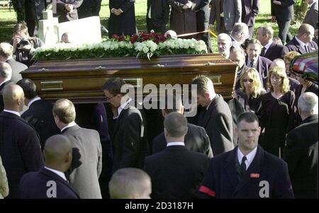 Roberta Kray (rechts neben einer Frau mit Sonnenbrille), die Frau des ehemaligen Ost-London-Gangsters Reggie Kray, beobachtet, wie sein Sarg zum Grab auf dem Friedhof von Chingford getragen wird. Stockfoto