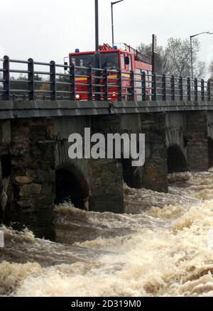 Ein Feuerwehrmotor überquert den Avoca River, auf der Hauptbrücke, die die Stadt Arklow, Co. Wicklow, Irland, trennt. Der Fluss, der an Orten nach sintflutartigen Regenfällen seine Ufer gebrochen hat, hat in der Nacht zur Evakuierung der Anwohner geführt. Stockfoto