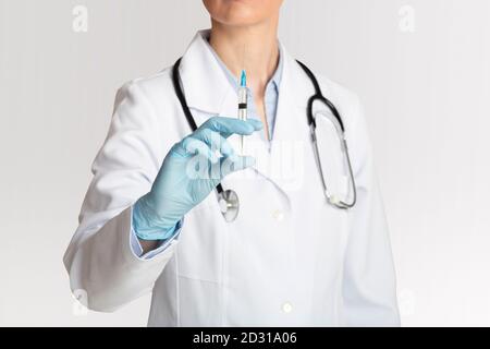 Gesundheitsversorgung, Behandlung und Injektion gegen Coronavirus. Ärztin hält Spritze für die Impfung Stockfoto