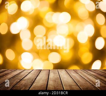 Leerer Holztisch vor abstrakt verschwommenem Hintergrund mit goldenen Lichtpunkten und Bokeh. Stockfoto