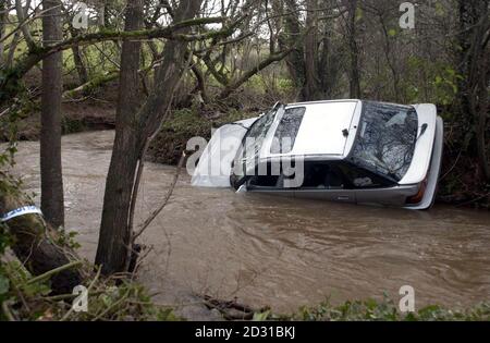 Ein Auto liegt in einem Fluss in Cheriton Fitzpaine, Devon, nachdem es die Straße verlassen und mit dem Verlust von zwei Menschenleben in den Bach gespült wurde. Der Unfall ereignete sich, als Regen- und Sturmwind Südengland niederschlugen. * die Leiche der Frau wurde im umgedrehten Fahrzeug gefunden, nachdem das Auto über eine Brücke gefahren war. Ihr Begleiter im Fahrzeug wurde von starken Strömungen weggefegt. Später wurde sein Körper von der Polizei geborgen. Stockfoto