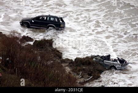 Die Überreste von zwei Autos bei einem Erdrutsch in Nefyn auf der abgelegenen Halbinsel Lleyn in Nordwales, bei dem eine Frau getötet und ein Mann schwer verletzt wurde. Es wurde angenommen, dass sieben Autos im Erdrutsch gefangen wurden. * bei zwei von ihnen wurde berichtet, dass mindestens 40ft nach unten in Richtung Meer gefegt worden sind und wurden aus dem Schlamm stehen gelassen, als Rettungsdienste eine große Rettungsaktion im Angesicht einer einströmenden Flut gestartet haben. Die verstorbene Frau wurde von einem Rettungsboot geborgen, aber am Rettungsbootstützpunkt in der Nähe von Porthdinllaen für tot erklärt. Stockfoto