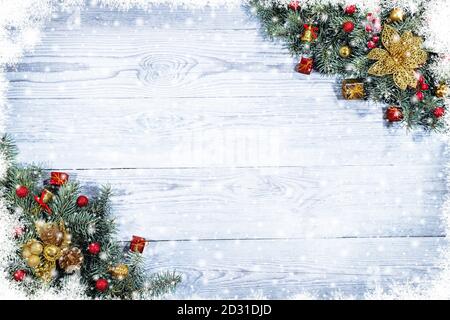Tannenzweige mit Spielzeug auf altem Holztisch mit Bokeh-Licht. Schöne Weihnachten Hintergrund. Stockfoto