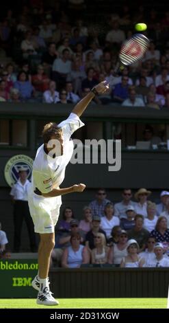 KEINE KOMMERZIELLE NUTZUNG: Der britische Greg Rusedski dient Andrei Pavel während des ersten Rundenmatches der Lawn Tennis Championships in Wimbledon, London. Stockfoto