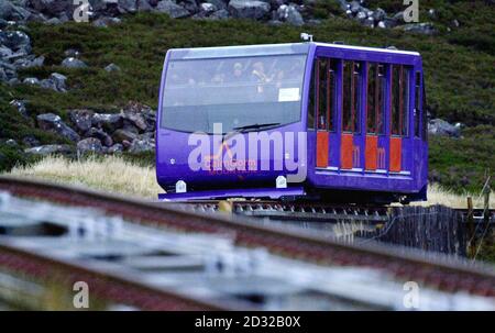 Die CairnGorm Funicular Railway befördert Passagiere am ersten Tag ihrer Eröffnung auf einer 2 km langen Strecke am Berghang. Die 15 Millionen Bahnstrecke AS Coire Cas, Glen More, in der Nähe des Skigebiets Aviemore soll die Sessellifte der White Lady ersetzen. * die 1961 installiert wurden, um Skifahrer den Berg hinauf zu tragen, und es ist zu hoffen, dass sie den Tourismus in den schottischen Highlands ankurbeln werden. Der Zug kann auf jeder Fahrt bis zu 120 Passagiere befördern und kann den 453 Meter hohen Aufstieg vom Parkplatz bis knapp unter den Gipfel in etwa sechs Minuten bewältigen und bei Windgeschwindigkeiten von bis zu t fahren Stockfoto