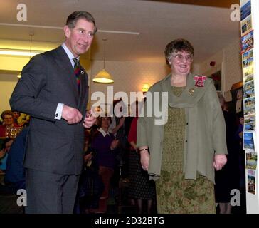 Der Prinz von Wales gratuliert der 55-jährige Krankenschwester Dyfanwen Jones, nachdem sie ihr während eines Besuchs im Usk House Tageszentrum für Krebspatienten in Brecon einen MBE vorgestellt hatte. * ... Sie erhielt die Ehre für ihre Gemeinschaftsarbeit, konnte aber nicht an der Zeremonie im Buckingham Palace teilnehmen, weil ihre Patienten nicht kommen konnten. Stockfoto