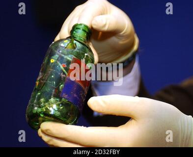 Ein Polizist hält eine Flasche, Glas, aus dem die Polizei glaubt, wurde verwendet, um 10-jährige Damilola Taylor in Peckham zu töten November 2002, auf einer Scotland Yard Pressekonferenz. Zuvor wurden zwei Jugendliche im Old Bailey des Mordes an Damilola hingenommen. Stockfoto