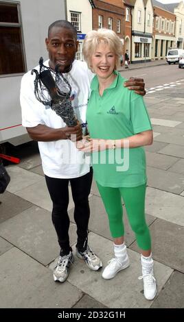 Der ehemalige Boxweltmeister Frank Bruno übergab die Millennium-Flamme an die Grüne Göttin Diana Moran im Fernsehen während einer Fotocolalle in Billericay, Essex, im Rahmen des Cancer Research UK-British Gas Golden Jubilee Summer Party Fackel Relay. Stockfoto