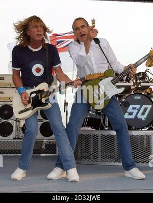 Rick Parfitt (links) und Francis Rossi von Status Quo spielen für Fans und Segler an Bord der HMS Ark Royal in Portsmouth. Die Band inszenierte das Konzert, um ihr neues Album Heavy Traffic zu promoten. Stockfoto