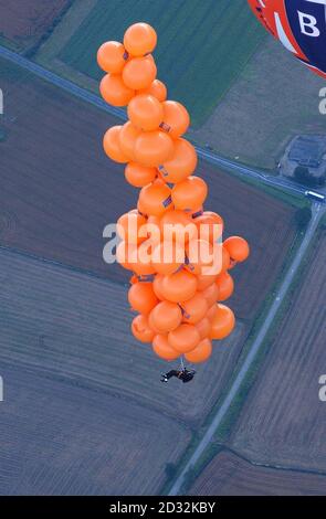 Mike Howard baumelt bei der Bristol Balloon Fiesta unter Hunderten von mit Helium gefüllten Ballons. Howard, gekleidet als sein waghalsiger Held in einer Abendjacke, stieg auf mehr als 7.000ft, konnte aber nicht hoch genug steigen, um den Weltrekord von 11.000ft wegen schwerer Wolkendecke zu brechen. Stockfoto