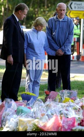 Hauptsuperintendent Craig Denholm (links) steht mit Bob (rechts) und Sally Dowler, Eltern der ermordeten Schülerin Amanda Dowler in Yatley Heath Woods, Minley, in der Nähe von Fleet, Hampshire, wo sie sich die geblümten Tribute für ihre Tochter ansahen. *...die trauernden Eltern Milly Dowler besuchten die Waldfläche, wo die Überreste des Teenagers gefunden wurden. IT-Berater Bob, 51, und seine Frau Sally, eine 43-jährige Lehrerin, verbrachten heute Nachmittag 30 Minuten in Yateley Heath Woods. Stockfoto