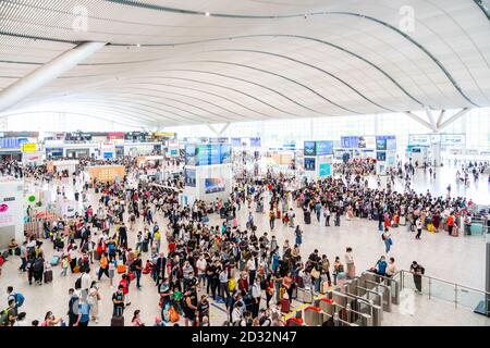 Massen von chinesischen Reisenden mit Schutzmasken warten in Warteschlangen an den Einstiegstoren des Shenzhen Nordbahnhofs, als sie den Nationalfeiertag in China beenden, der auch als die goldene Woche bekannt ist. Stockfoto