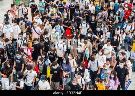 Massen von chinesischen Reisenden mit Schutzmasken warten in Warteschlangen an den Einstiegstoren des Shenzhen Nordbahnhofs, als sie den Nationalfeiertag in China beenden, der auch als die goldene Woche bekannt ist. Stockfoto