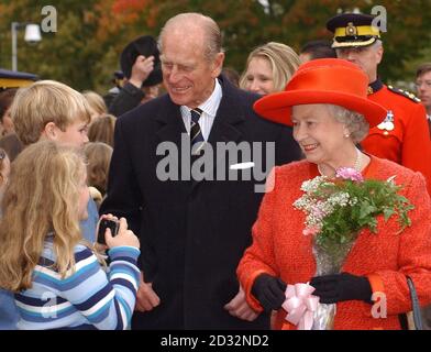 Die britische Königin Elizabeth II. Und der Herzog von Edinburgh genießen einen Spaziergang, nachdem sie das Old Government House in Fredericton, New Brunswick, während ihres zweiwöchigen königlichen Besuches in Kanada besucht haben. Stockfoto