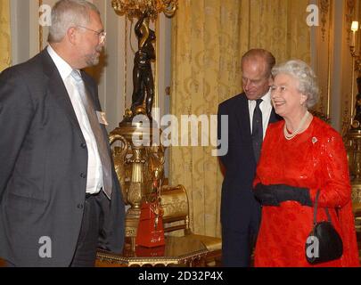 Die britische Königin Elizabeth II. Steht mit dem Duke of Edinburgh zusammen, als ihr eine goldene Disc für die DVD und das Video von Party at the Palace und das goldene Metronom präsentiert wird, mit dem sie im Juni das BBC Music Live-Event startete. Von Gavyn Davies Vorsitzender der BBC (links), im Buckingham Palace, London, bei einem Empfang für Jubilee-Organisatoren, Mittwoch, 30. Oktober 2002. Stockfoto