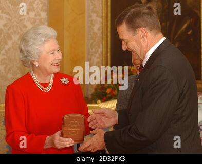 Die britische Königin Elizabeth II. Erhält den Gouverneur von Westaustralien John Sanderson, der der Königin eine australische Jubilee-Medaille geschenkt hat. Die Königin empfing auch Frau Sanderson im Buckingham Palace. Stockfoto