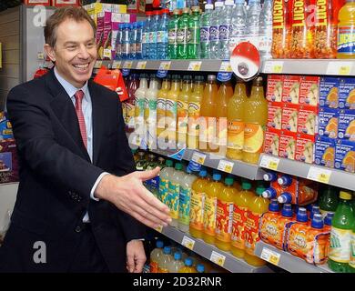 Premierminister Tony Blair reicht seine Hand, um die Mitarbeiter im Co-op-Laden in Middlesbrough zu begrüßen. Herr und Frau Blair haben in einem neu eröffneten Co-op-Laden einen halben Kilometer von ihrem Wahlkreis entfernt Weihnachtseinkäufe gemacht und einen Stapel Schokolade und eine Flasche Whisky gekauft. Stockfoto