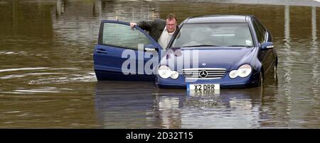 Sequenzbild 2/3. Ein Autofahrer in einem Mercedes versucht, durch einen großen Wasserpool zu fahren, der die Zufahrtsstraße an der Anschlussstelle 1 der Autobahn M 50 bei Tewkesbury bedeckt. Das Auto blieb im Wasser stehen, und dann musste der Fahrer sein Auto bis zum Rand schieben. *... bevor er schließlich einen Abschleppwagen von einem vorbeifahrenden Van annahm. Stockfoto