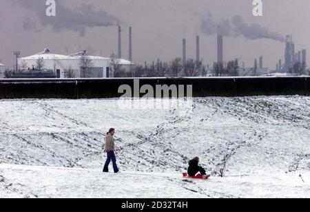 Canvey Island in Essex, wo es heftige Schneefälle gab. Im Schnee spielen die Kids von Canvey mit Canvey Gas arbeitet im Hintergrund. * in einer Nacht mit starkem Frost sanken die Temperaturen in Farnborough, Hampshire und Hawarden im Nordosten von Wales bis auf minus 8C und in der Highland-Stadt Aviemore bis auf minus 16C. Stockfoto