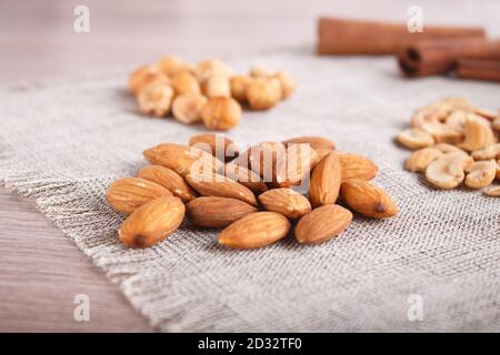 Zimt, Mandeln, Haselnüsse, Cashew auf Leinenserviette. Stillleben. Nahaufnahme. Stockfoto