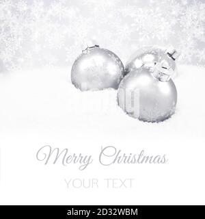 Drei silberne Weihnachtskugeln auf silbernem Hintergrund Stockfoto