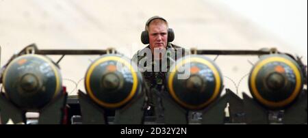 Ein britischer Waffentechniker der Royal Air Force, Senior Aircraftman Barry Jones, sieht zu, wie er hinter einem Wagen voller 500lb Freifallbomben sitzt, während ein britischer Harrier GR7 auf seiner Basis in Kuwait zur Startbahn tastet. * Großbritannien sagte, dass IS fast sicher sei, dass zwei tote Soldaten, deren Leichen im Al-Jazeera-Fernsehen in Katar gezeigt wurden, tatsächlich Briten seien, wie der Sender behauptete. Stockfoto