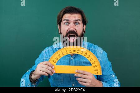 Mann überrascht mit Größe gemessen auf Winkelmesser Lineal Mathematik Werkzeug, Schulbildung. Stockfoto