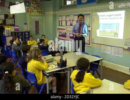 Schulstandardminister David Miliband unterrichtet eine Klasse von 9-10-Jährigen an der St Paul's School in Whitechapel, East London. Sie nahmen an dem Teil, was als die größte Lektion der Welt jemals in Rechnung gestellt wurde. * bei dem Rekordversuch wurden mehr als 200,000 Schulkinder in mehr als 100 Ländern in derselben Lektion unterrichtet. Stockfoto