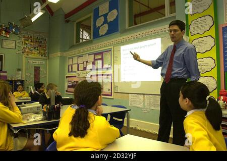 Schulstandardminister David Miliband unterrichtet eine Klasse von 9-10-Jährigen an der St Paul's School in Whitechapel, East London. Sie nahmen an dem Teil, was als die größte Lektion der Welt jemals in Rechnung gestellt wurde. * bei dem Rekordversuch wurden mehr als 200,000 Schulkinder in mehr als 100 Ländern in derselben Lektion unterrichtet. Stockfoto