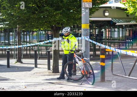 Ein männlicher Polizeibeamter der Gemeinde steht mit seinem Fahrrad, das eine Absperrung bewacht; West Midlands Police, Birmingham Stockfoto