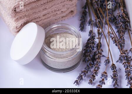 Natürliche handgemachte Peeling oder Gesichtsmaske mit Lavendel, trockene Blumen und Handtücher, Draufsicht. Spa- und Wellness-Konzept. Stockfoto