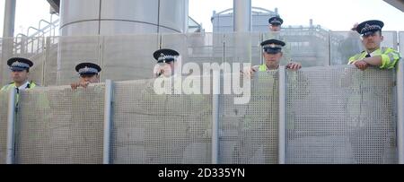 Polizeibeamte behalten die Demonstranten im Excel-Ausstellungszentrum in den Londoner Docklands im Auge, wo diese Woche eine internationale Waffenmesse stattfindet. Die Veranstaltung, Europas größte Waffenmesse, wurde heute inmitten strengem Sicherheitsaff eröffnet, aber die Proteste waren gedämpft. Die Polizei verhaftete 51 Personen im Vorfeld der Veranstaltung und drei weitere Personen wurden heute Morgen festgenommen, aber es gab keine Versuche, die Sicherheit zu durchbrechen. Die Demonstranten demonstrieren weltweit gegen den Verkauf von Militärwaffen. Stockfoto