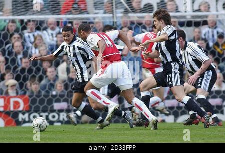 Arsenals Thierry Henry (Mitte) in Aktion gegen die Verteidigung von Newcastle United während des Barclaycard Premiership-Spiels im St. James' Park in Newcastle. Newcastle United Drew 0-0 mit Arsenal. DIESES BILD KANN NUR IM RAHMEN EINER REDAKTIONELLEN FUNKTION VERWENDET WERDEN. KEINE WEBSITE-/INTERNETNUTZUNG, ES SEI DENN, DIE WEBSITE IST BEI DER FOOTBALL ASSOCIATION PREMIER LEAGUE REGISTRIERT. Stockfoto