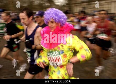 Ein als Clown gekleideter Läufer läuft zum Start des London-Marathons 2004 in Greenwich, South East London. Stockfoto