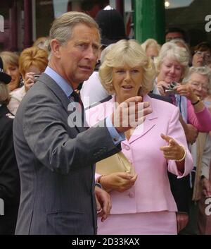 Der Prinz von Wales und seine Partnerin Camilla Parker-Bowles grüßen die Mitglieder der Öffentlichkeit vor dem Merchant's House in Marlborough in Wiltshire, wo sie dem Prinzen zwei "Bobby Vans" zeigte, ein Verbrechensverhütungsschema, dessen Treuhänder sie ist. Stockfoto