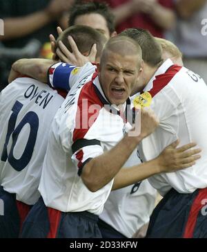 Der englische Michael Owen (links) wird von Teamkollegen nach dem Tor zum Eröffnungstreffer gegen Portugal gratuliert, wie Kapitän David Beckham beim Viertelfinalspiel der Euro 2004 im Estadio de Luz in Lissabon, Portugal, ansieht. Stockfoto