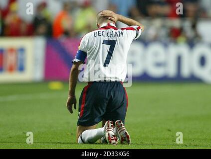 Der englische David Beckham hält sich nach einer Herausforderung gegen Portugal während des Viertelfinalsspiel der Euro 2004 beim Estadio de Luz in Lissabon, Portugal, unwohl am Kopf. NUR FÜR REDAKTIONELLE ZWECKE, KEINE VERWENDUNG VON MOBILTELEFONEN ODER PDAS. INTERNETNUTZUNG NUR AUF VON DER UEFA AUTORISIERTEN WEBSITES UND DANN KÖNNEN NICHT MEHR ALS 10 FOTOS PRO HÄLFTE DER NORMALEN SPIELZEIT UND FÜNF FOTOS PRO HÄLFTE DER ZUSÄTZLICHEN ZEIT ÜBER DAS INTERNET MIT EINEM INTERVALL VON MINDESTENS EINER MINUTE ZWISCHEN DER VERÖFFENTLICHUNG JEDES SOLCHEN FOTOS VERÖFFENTLICHT WERDEN. Stockfoto