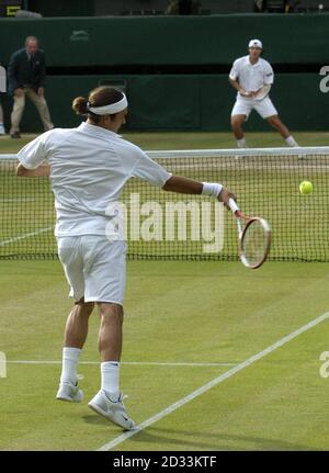 Titelverteidiger Roger Federer aus der Schweiz gegen Sebastien Grosjean aus Frankreich im Halbfinale des Herren-Singles-Turniers bei den Lawn Tennis Championships in Wimbledon, London. NUR FÜR REDAKTIONELLE ZWECKE, KEINE VERWENDUNG VON MOBILTELEFONEN. Stockfoto